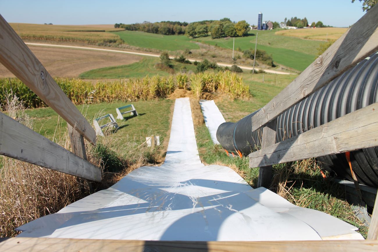 long white slide goes into a farm field.