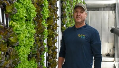 Tony Rahe stands next to a wall of lettuce in one of his hydroponic growing containers at Rahe of Sunshine Farms in Wykoff.