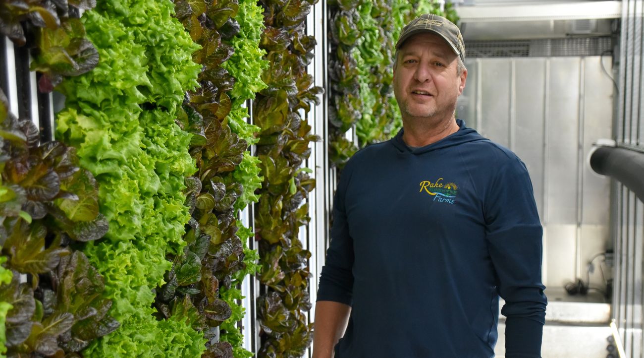 Tony Rahe stands next to a wall of lettuce in one of his hydroponic growing containers at Rahe of Sunshine Farms in Wykoff.