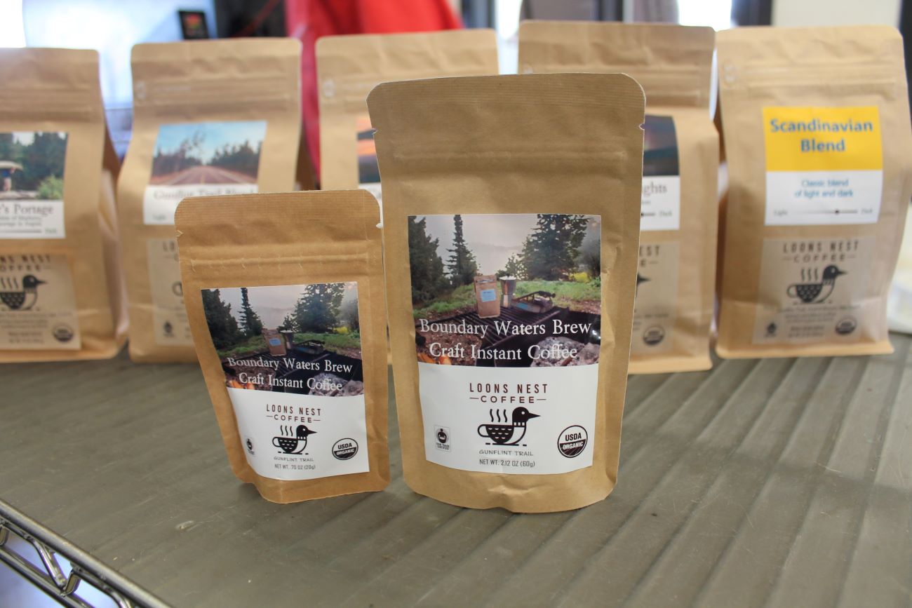 Brown paper bags of instant coffee with labeled with the flavor and the Loons Nest logo.