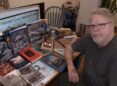 man at table with book and magazine covers