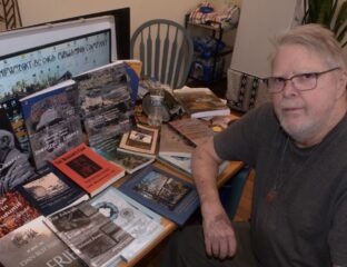 man at table with book and magazine covers