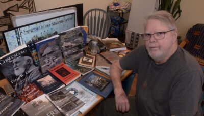 man at table with book and magazine covers