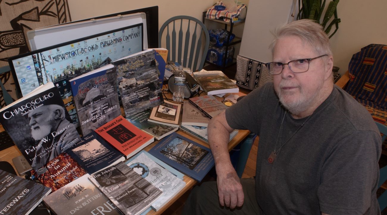 man at table with book and magazine covers