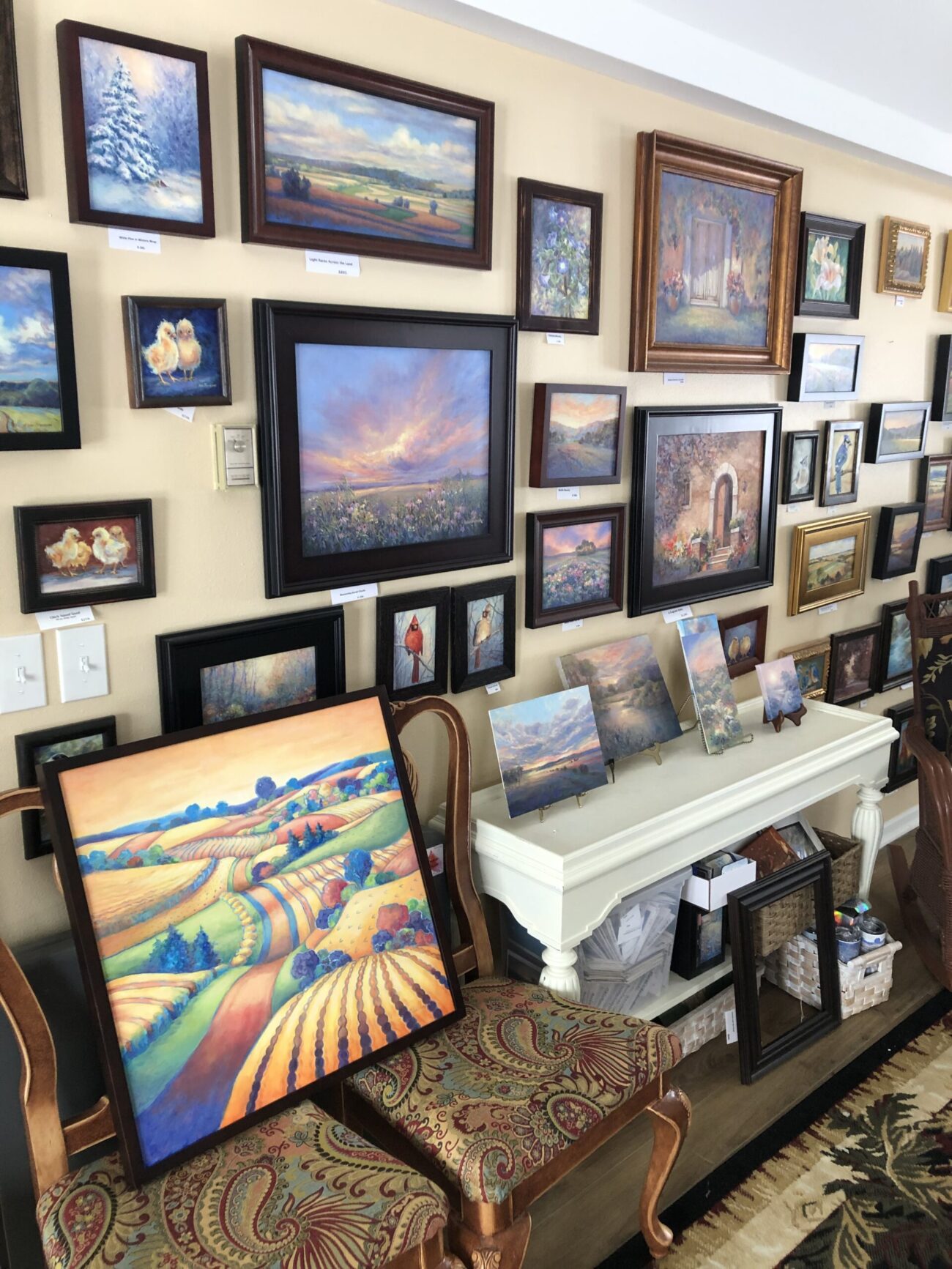 A wall covered in framed paintings.