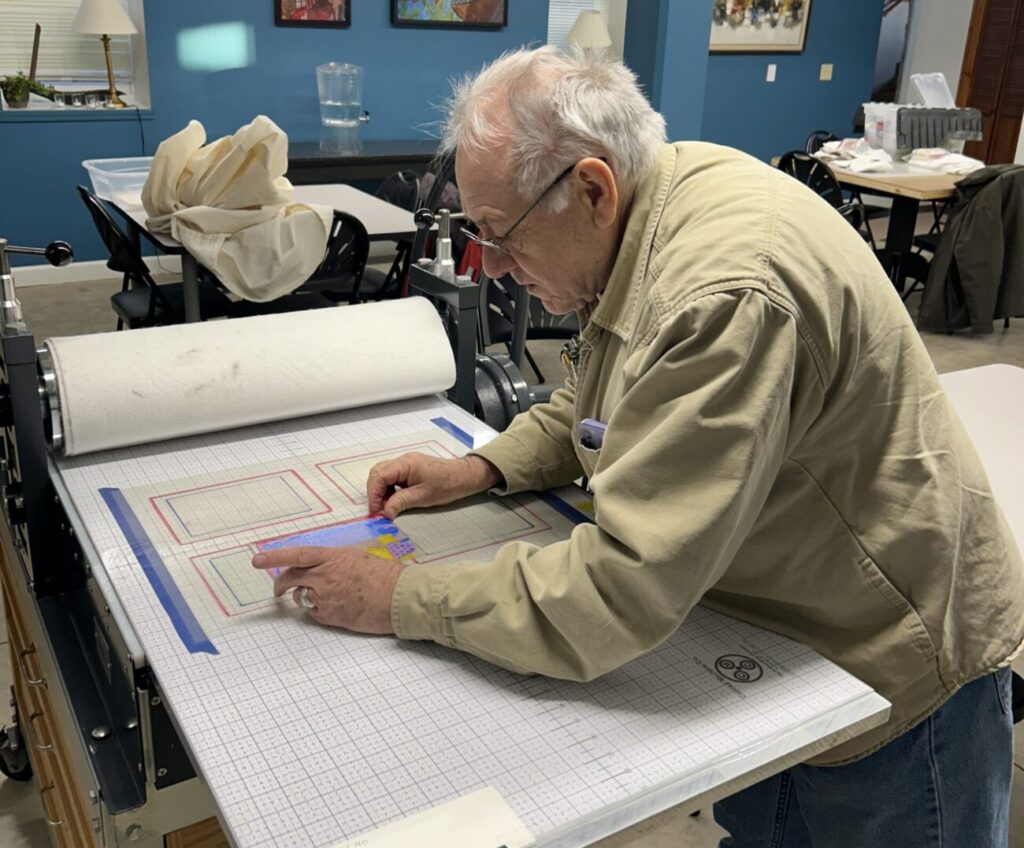 a man in tan shirt working on table press