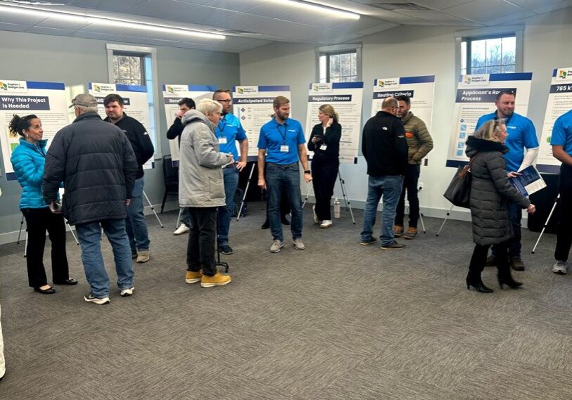 Community members talk with utility staff at a Dairyland Power open house in Preston, Minnesota, reviewing poster displays about the proposed Gopher-to-Badger high-voltage transmission line project.