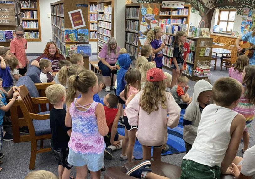 1-MIKKI-AND-KELLI Musician Will Bjorndal offers a program of fun music and dancing for kids at Spring Grove Public Library, an example of SELCO and Legacy Funds at work. (Photo by Jana Halverson)