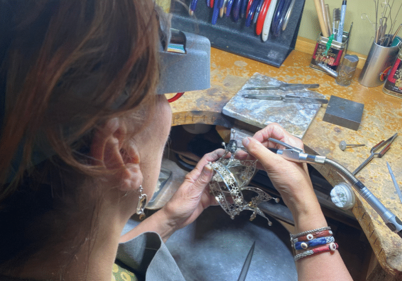 <span style="font-size: 14px; color: #6c6b6b; ">Liz at her shop workbench working on a crown repair. (Photos for this article were provided by Liz Bucheit)</span>