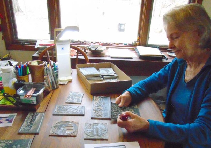 PHOTO 1 MARY H COLOR copy <span style="font-size: 14px; color: #6c6b6b; ">Artist Mary Denzer is pictured working on Lino prints for her late husband’s book of poetry. (Photo by Delia Bell)</span>