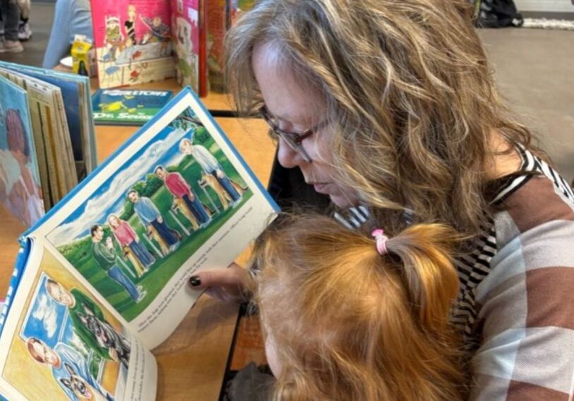 PHOTO 1 RRC The READ Act New Teaching Methods for Reading in Minnesota By Alison Leathers March 2025 A woman with blonde-brown hair reads a picture book to a child with red hair pulled back in a partial pony tail.