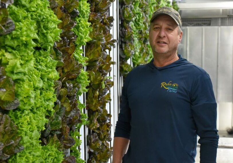 PHOTO 1 Rahe of Sunshine Hero image Tony Rahe stands next to a wall of lettuce in one of his hydroponic growing containers at Rahe of Sunshine Farms in Wykoff.