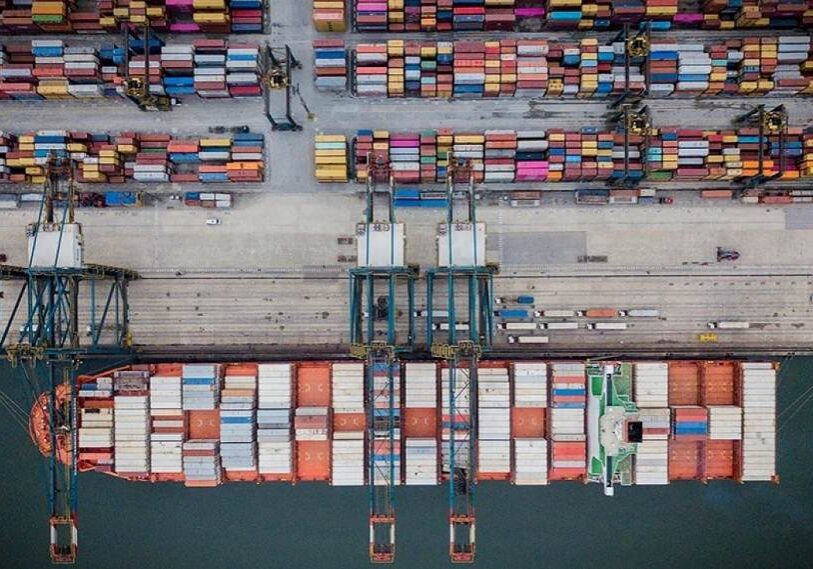 Aerial view of container ships and cargo cranes at the Port of Santos in Brazil, a major global export hub handling a large share of South American soybean shipments.