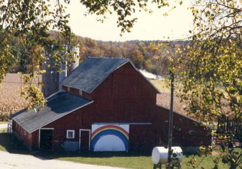 A poem inspired by an image is called an Ekphrasis poem. This photo inspired the poem Double Vision. The photo was taken in September 1987 – “the corn still standing, with fall color (and gravel dust) in the distance.” The barn has since been torn down, but the rainbow door was saved. (Photo by Berta Aug)